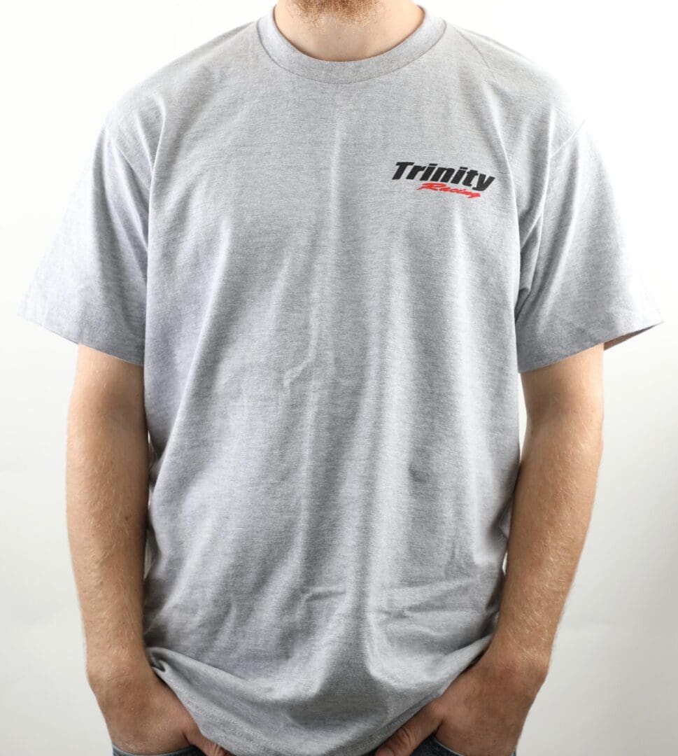 A man wearing a gray t-shirt with the word trinity on it.