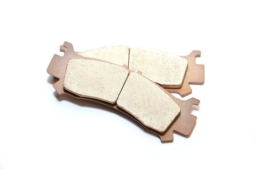 A pair of brake pads sitting on top of a white surface.