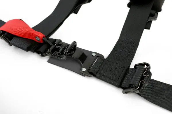 A red and black harness on top of a white table.