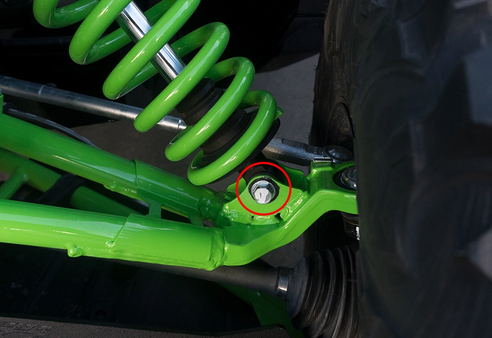 A close up of the front suspension on a green vehicle.