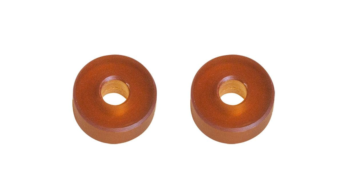 A pair of orange rubber washers sitting on top of a white table.